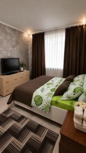 a bedroom with a large bed and a television at Машхур Жусупа 25 in Pavlodar