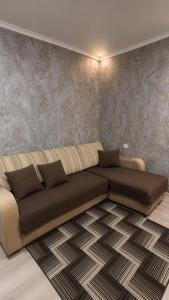a living room with a large couch in a room at Машхур Жусупа 25 in Pavlodar