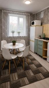 a kitchen with a table and chairs in a room at Машхур Жусупа 25 in Pavlodar