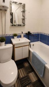 a bathroom with a toilet and a sink and a tub at Машхур Жусупа 25 in Pavlodar