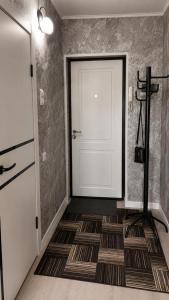 a room with a white door and a brown floor at Машхур Жусупа 25 in Pavlodar