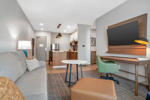 a living room with a couch and a desk with a tv at Staybridge Suites Crestview South by IHG in Crestview