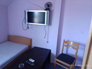 a small room with a bed and a tv and a chair at Pit - Stop 