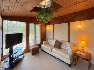 a living room with a couch and a flat screen tv at Hidden Oasis Near Downtown in Eureka Springs