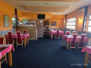 a restaurant with pink tables and chairs and a bar at Pit - Stop 