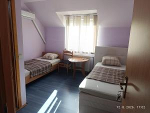 a small room with two beds and a table at Pit - Stop 