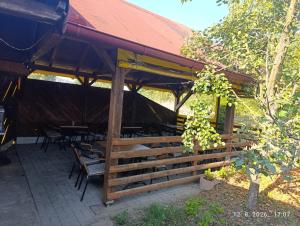 a wooden pavilion with tables and chairs under it at Pit - Stop 