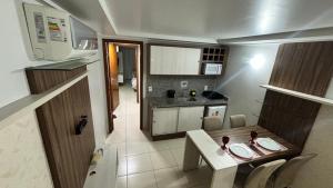 a small kitchen with a dining table and a kitchen at Blue Sunset Experince - Cabo Branco in João Pessoa