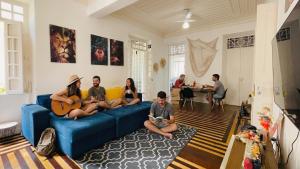 a group of people sitting on a blue couch in a living room at Odara Hostel & Guesthouse in Salvador