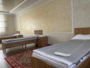 a bedroom with two beds and a rug at Moto Guest House in Kochkorka