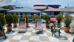 a patio with chairs and potted plants on a roof at Welcome to Kobuleti in Kobuleti
