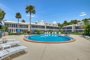 a large building with a swimming pool and lounge chairs at Boat Dock, Slips & Pool! St Johns River Condo in Welaka