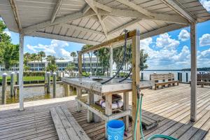 a wooden deck with a table and benches on the water at Boat Dock, Slips & Pool! St Johns River Condo in Welaka