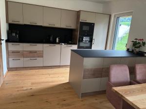 a kitchen with white cabinets and a black counter top at Alpenoase Ennstal in Ennsling