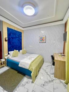 a bedroom with a bed and a large window at Bisso Hotel Bonaberi in Douala