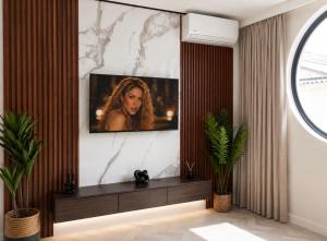 a living room with a tv on a wall at City Centre Oasis in Cape Town +8 photos