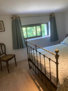 a bedroom with a bed and a chair and a window at Atelier chambres in Semur-en-Auxois