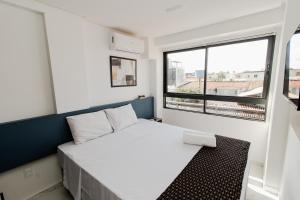 a small bedroom with a white bed and a window at Smeralda del Mare by AFT in Porto De Galinhas +20 photos