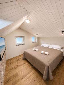 a bedroom with a large bed with two towels on it at Saules apartment Klaipeda in Klaipėda