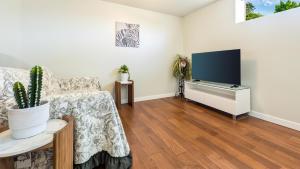 a living room with a couch and a flat screen tv at Sunny Crest Burnaby-cozy one bedroom private suite in Burnaby +3 photos