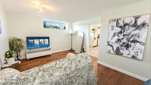 a living room with a couch and a tv at Sunny Crest Burnaby-cozy one bedroom private suite in Burnaby