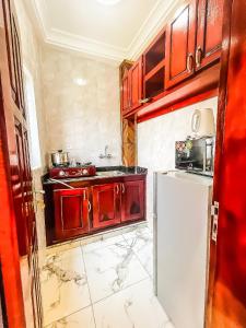 a kitchen with red cabinets and a white refrigerator at Bisso Hotel Bonaberi in Douala +30 photos