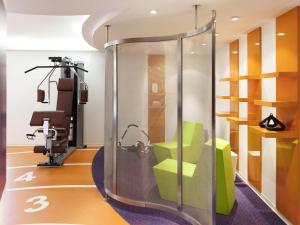 a room with a gym with a chair and a treadmill at Novotel Metz Centre in Metz