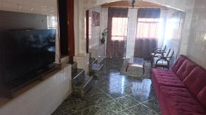 a living room with a couch and a flat screen tv at Casa para temporada in Ouro Preto