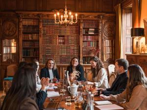 a group of people sitting around a table in a library at Hotel Novotel Domaine de Maffliers - Paris Val-d'Oise in Maffliers
