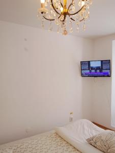 a bedroom with a bed and a chandelier at Brasov Sfat Apartament in Braşov