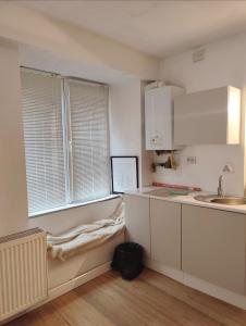 a kitchen with white cabinets and a sink and a window at Brasov Sfat Apartament in Braşov