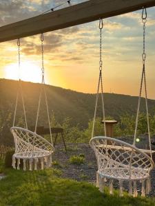 two swings with the sunset in the background at SkyCamp Almaty in Almaty