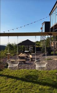 a picnic shelter with swings and a picnic table at SkyCamp Almaty in Almaty