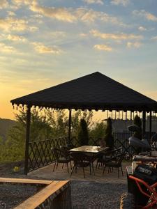 a table and chairs under a black umbrella at SkyCamp Almaty in Almaty