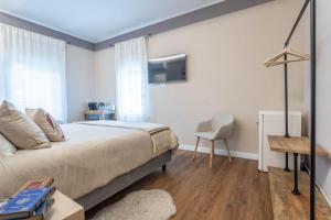 a bedroom with a bed and a chair and a tv at valter rooms 1 in Castel del Piano