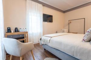 a bedroom with a bed and a chair and a window at valter rooms 1 in Castel del Piano