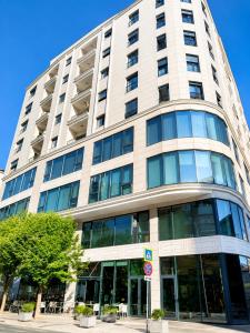 a tall white building with a lot of windows at Green Terrace Square View in Tirana