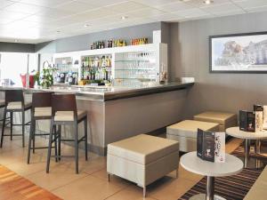 a bar in a restaurant with chairs and a counter at Novotel Nantes Carquefou in Carquefou