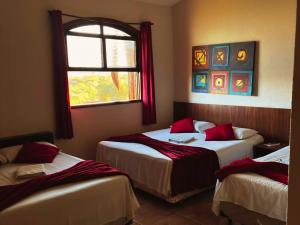 a bedroom with two beds and a window at Fazenda Itaygua Hotel in Ribeirão Preto
