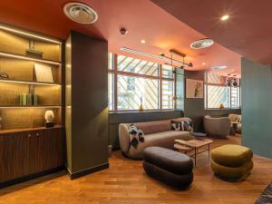 a living room with a couch and a table at Nest Hotel Paris la Défense - MGallery Collection in Puteaux