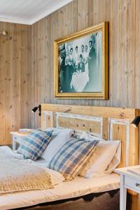 a bedroom with a bed with a picture on the wall at Lodge Visnes Stryn in Stryn
