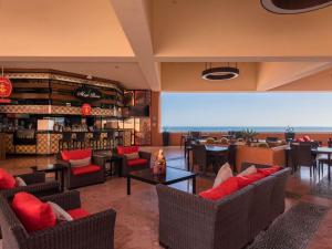 a restaurant with couches and tables and a bar at Club Regina Los Cabos in San José del Cabo