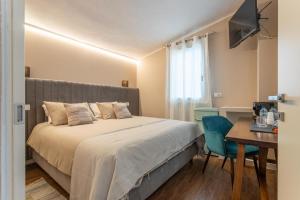 a bedroom with a bed and a table with a chair at valter rooms 2 in Castel del Piano