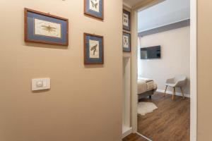 a hallway with a room with a bed and pictures on the wall at valter rooms 2 in Castel del Piano