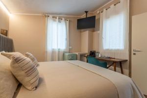 a bedroom with a bed with a desk and a window at valter rooms 2 in Castel del Piano