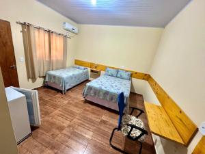 a room with two beds and a table and a tv at Pousada Canela de Ema in Mateiros +29 photos