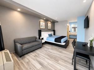 a hotel room with a bed and a couch and a desk at Crystal Inn Downtown in Houston