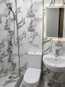 a white bathroom with a toilet and a sink at Red Pyramids Hotel in Cairo