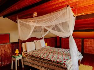 a bedroom with a bed with a canopy at Canoa Nativa Pousada Boipeba in Ilha de Boipeba