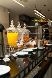 a counter in a kitchen with glasses and plates on it at Comfort Hotel Campos dos Goytacazes in Campos dos Goytacazes